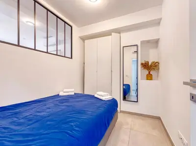 a bedroom with a large blue bed in a room at City Vibes, Indoor Parking, Breakfast & Air Conditioning in Nice