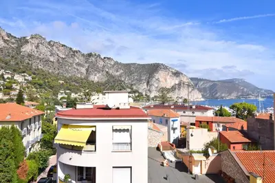 a view of a town with a mountain in the background at Beaulieu Sur Mer: Superbe Appart avec vue Mer in Beaulieu-sur-Mer