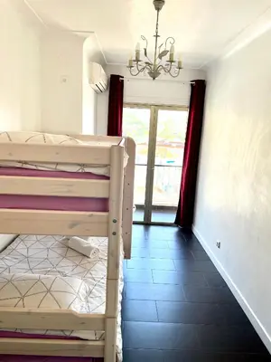 a bedroom with a bunk bed and a chandelier at Beaulieu Sur Mer: Superbe Appart avec vue Mer in Beaulieu-sur-Mer