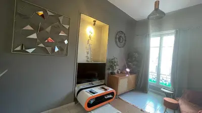 a living room with a tv and a table at Appartement au centre de Nice in Nice
