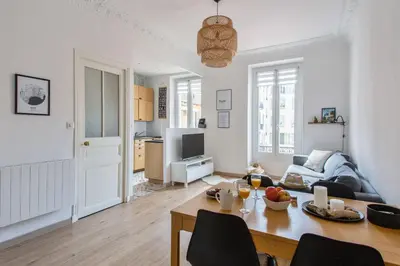 a living room with a table and a couch at Appartement Pertinax - Welkeys in Nice