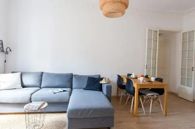 a living room with a blue couch and a table at Appartement Pertinax - Welkeys in Nice