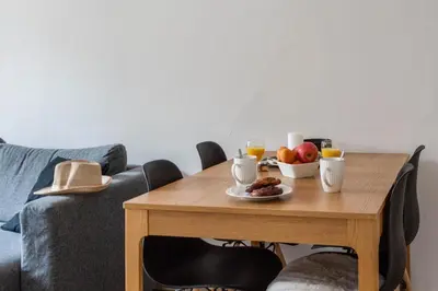 a wooden table with a bowl of fruit and glasses of orange juice at Appartement Pertinax - Welkeys in Nice