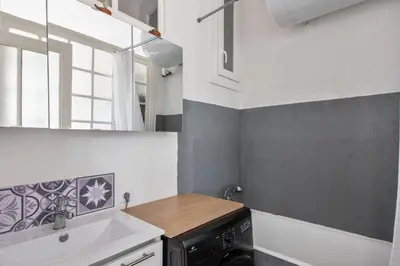 a small kitchen with a sink and a washing machine at Appartement Pertinax - Welkeys in Nice
