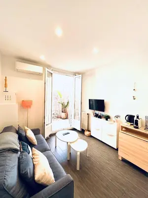a living room with a couch and a table at Studio Cocooning avec terrasse au calme Quartier Les Musiciens Mer à 7 minutes à pieds in Nice