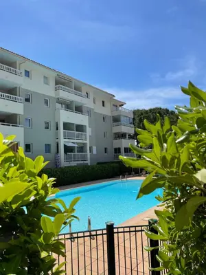 a swimming pool in front of a building at Appartement avec piscine privée in Cagnes-sur-Mer