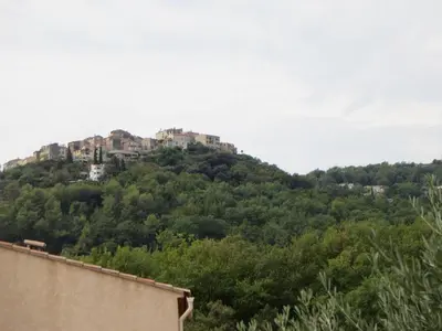a building on top of a hill with trees at 2P entre mer et montagne in Gattières