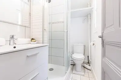 a white bathroom with a toilet and a sink at Open Sky Terrace Downtown Studio in Nice