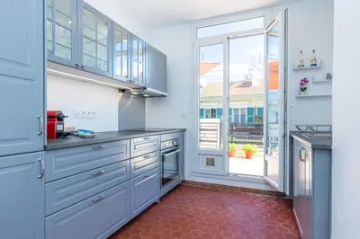 a kitchen with blue cabinets and a red tile floor at Open Sky Terrace Downtown Studio in Nice
