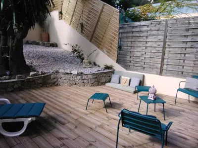 a patio with chairs and a couch on a wooden deck at NICE- GAIRAUT - JARDIN PRIVE- GRAND F1 LUMINEUX-Piscine Collective in Nice