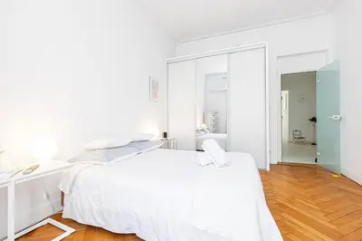 a white bedroom with a white bed and a desk at FEEL HOME - GRIMALDI in Nice