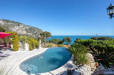 a swimming pool with the ocean in the background at Villa Panorama in Èze