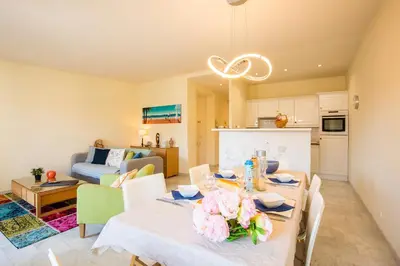 a dining room and living room with a table and chairs at LE FOCH AP4244 By Riviera Holiday Homes in Nice