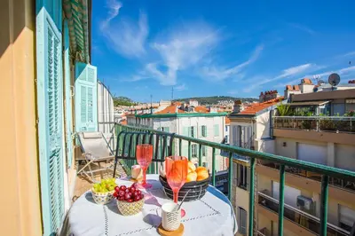 a balcony with a table with fruit and wine glasses at LE FOCH AP4244 By Riviera Holiday Homes in Nice
