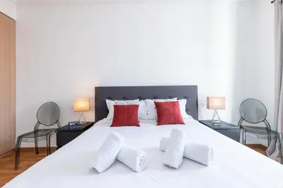 a bedroom with a large white bed with red pillows at Sea View Large 2 Bdr Promenade des Anglais in Nice