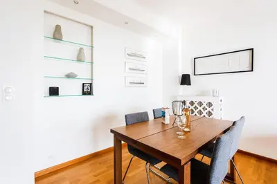 a dining room with a wooden table and chairs at Terrace on the Bay 2 Villefranche-sur-Mer, AP4243 by Riviera Holiday Homes in Villefranche-sur-Mer