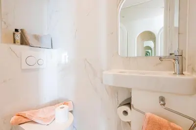 a white bathroom with a sink and a mirror at Terrace on the Bay 2 Villefranche-sur-Mer, AP4243 by Riviera Holiday Homes in Villefranche-sur-Mer
