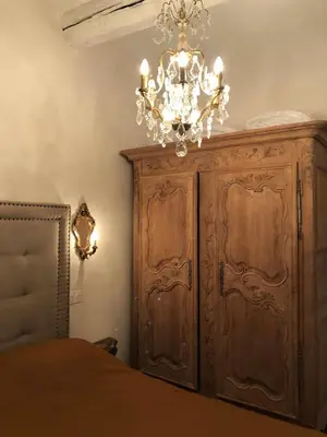a bedroom with a wooden cabinet and a chandelier at Petit Palace in Old Nice in Nice