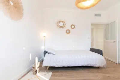 a white bedroom with a bed and mirrors on the wall at Maison Bianchi - Villefranche in Villefranche-sur-Mer
