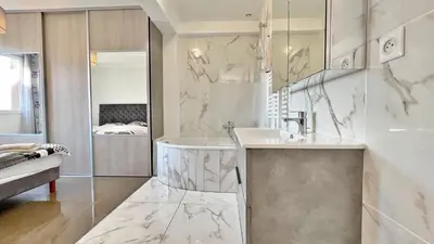 a white bathroom with a sink and a mirror at L'Avenir du Ray in Nice