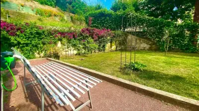 a white bench sitting in a garden with flowers at L'Avenir du Ray in Nice