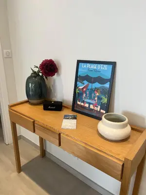 a wooden table with a picture and a vase on it at Villa LE CIEL D EZE in Èze