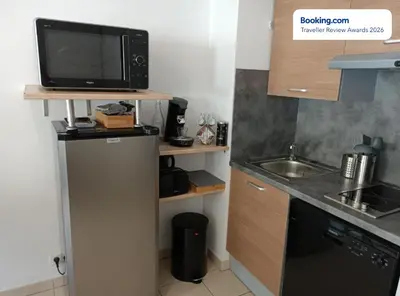 a small kitchen with a refrigerator and a microwave at Anicesleep Superbe appart au calme et à 5 mn de la Prom in Nice