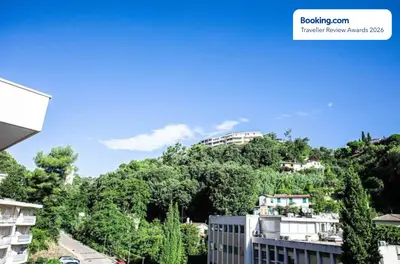a building on top of a hill with trees at Anicesleep Superbe appart au calme et à 5 mn de la Prom in Nice