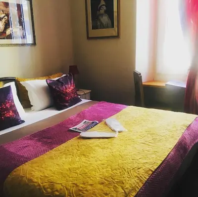 a bedroom with a large bed with a yellow blanket at Hotel Villa La Tour in Nice