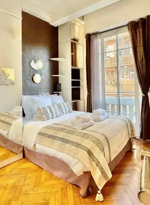a bedroom with a large bed and a large window at Swiss Star - Easy Home Booking in Nice