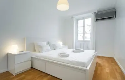 a white bedroom with a large white bed and a window at BIG WHITE in Nice