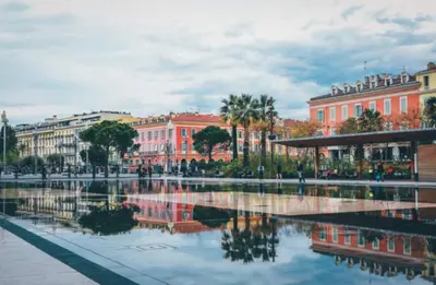 a city with a reflection of buildings in the water at Lovely Apartment Heart of Golden Square Fiber Wifi in Nice