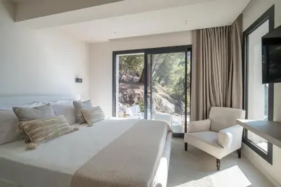 a bedroom with a large white bed and a chair at Villa Vista Mare by iVillamia com in Villefranche-sur-Mer