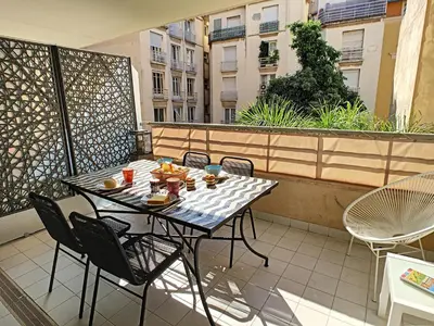 a table and chairs sitting on a balcony at Nestor&Jeeves - PALAIS MEDITERRANEE TERRASSE - Central - Very close sea in Nice