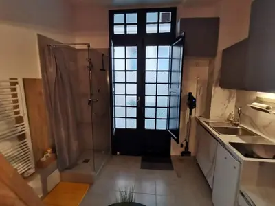 a bathroom with a shower and a glass door at Studette 