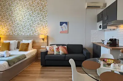 a woman standing in a kitchen next to a bed at Aparthotel AMMI Nice Massena - ex Ajoupa in Nice