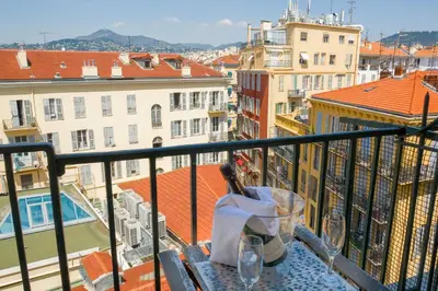a balcony with a table and chairs and a view at Aparthotel AMMI Nice Massena - ex Ajoupa in Nice