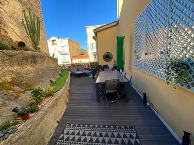 a patio with a table and chairs on the side of a building at ApartHotel Riviera - Terrasse Loft de la Providence - Vieille Ville - Esprit Loft en 2 pices AC in Nice
