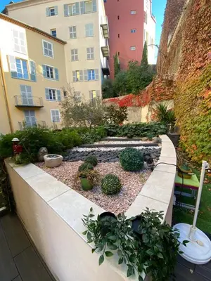 a garden with potted plants and a building at ApartHotel Riviera - Terrasse Loft de la Providence - Vieille Ville - Esprit Loft en 2 pices AC in Nice