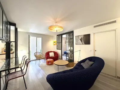 a living room with a blue couch and chairs at ApartHotel Riviera - Terrasse Loft de la Providence - Vieille Ville - Esprit Loft en 2 pices AC in Nice