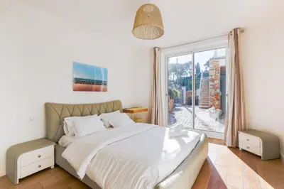 a bedroom with a bed and a large window at Villa Élégante Nice avec Vue Mer in Nice