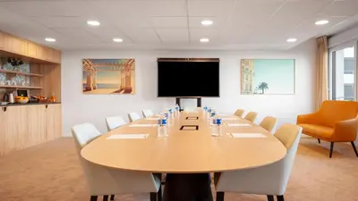 a conference room with a large table and a screen at Residhome Nice Aéroport in Nice