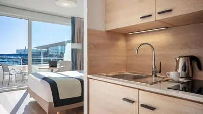a kitchen with a sink and a room with a view at Residhome Nice Aéroport in Nice