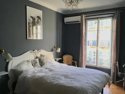 a bedroom with a white bed and a window at Modern, traditional , bright and stylish appartement in Nice