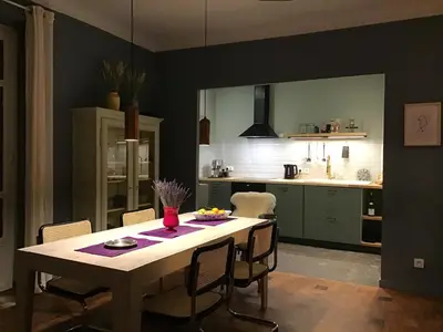 a kitchen with a table and chairs in a room at Modern, traditional , bright and stylish appartement in Nice