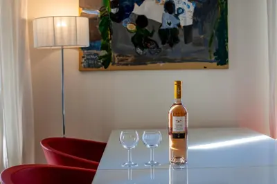 a bottle of wine sitting on a table with two wine glasses at Victor Hugo Palais AP3061 by Riviera Holiday Homes in Nice