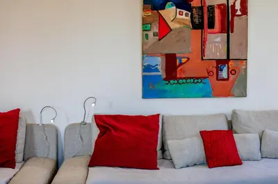 a couch with red pillows and a painting above it at Victor Hugo Palais AP3061 by Riviera Holiday Homes in Nice