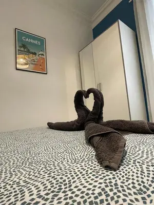a stuffed animal is laying on a bed at Joli appartement spacieux à 3 min à pied de la mer in Nice