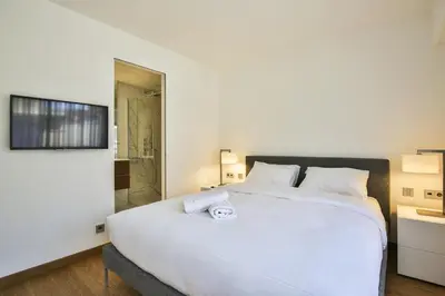 a bedroom with a large white bed and a shower at Sublime Appartement Promenade des Anglais (2) in Nice