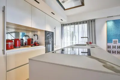a white kitchen with a sink and a counter at Sublime Appartement Promenade des Anglais (3) in Nice